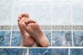 Wrinkled bare feet coming out from a bathtub. Young person getting a bath feet close-up indoor in bathroom interrior photo Royalty Free Stock Photo