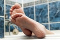 Wrinkled bare feet coming out from a bathtub. Young person getting a bath feet close-up indoor in bathroom interrior photo Royalty Free Stock Photo