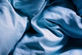 Wrinkled blue bed sheets on a morning as a background Royalty Free Stock Photo