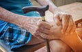 Wrinkled hand of old senior man with a cane stick