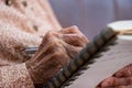 wrinkled hands for elderly person writing notes on here note book in living room Royalty Free Stock Photo