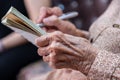 wrinkled hands for elderly person writing notes on here note book in living room Royalty Free Stock Photo