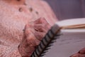 wrinkled hands for elderly person writing notes on here note book in living room Royalty Free Stock Photo