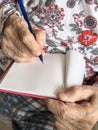 wrinkled hands of old person writing note Royalty Free Stock Photo