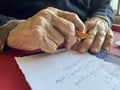wrinkled hands of old person writing shopping list in Turkish Royalty Free Stock Photo