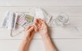 Senior hands with pills and drugs on table, glass of water.