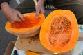 Wrinkled hands scooping out a ripe pumpkin from the seeds Royalty Free Stock Photo