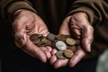 Wrinkled hands of senior man showing heap of coins on palms on dark background Royalty Free Stock Photo