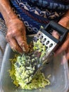 Wrinkled hands of a senior woman grating vegetables Royalty Free Stock Photo