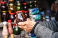 Wrinkled old female hands hold jar with jam