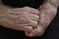 Wrinkled and old grandmother's hands clasped together