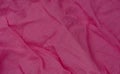 Wrinkled pink fabric texture background closeup