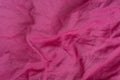 Wrinkled pink fabric texture background closeup