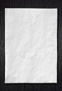 Wrinkled White paper on dark wood Royalty Free Stock Photo