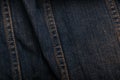 Wrinkled worn denim or grunge jeans fabric texture with orange tint and seams. Close up background or backdrop. Textile Royalty Free Stock Photo