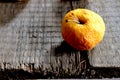 Wrinkled yellow apple on a board