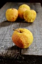 Wrinkled yellow apples on a wooden board