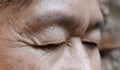 Wrinkles around closed eye of Asian elder man