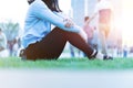 Wrist hand pain women sit on the green grass in the playground on sunset, city lifestyle concept Royalty Free Stock Photo