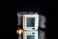 Wrist tonometer indicating that the patient must take pills for blood pressure.