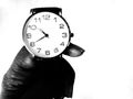 A wrist watch holding in hand by poor man. Black and white