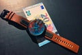 Wrist watch with leather strap near the banknote on a dark background Royalty Free Stock Photo