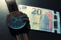 Wrist watch with leather strap near the banknote on a dark background Royalty Free Stock Photo