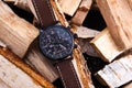 wrist watch men& x27;s brown leather strap on wood.