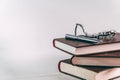 Wristwatch and pen on the pile of books on the table