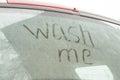 Write the words wash me on the very dirty surface of the car. Concept car wash