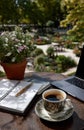 Writer enjoying coffee break in beautiful garden with laptop and notebook Royalty Free Stock Photo