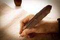 Writer holds a fountain pen over writing paper and a signature Royalty Free Stock Photo