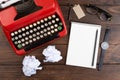 Writer or journalist workplace - vintage red typewriter, glasess and notepad on the wooden desk Royalty Free Stock Photo