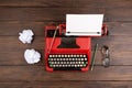 Writer or journalist workplace - vintage red typewriter, glasess and notepad on the wooden desk Royalty Free Stock Photo