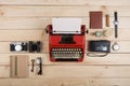 Writer or journalist workplace vintage red typewriter, photo camera, cassette recorder on the wooden desk Royalty Free Stock Photo