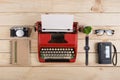 Writer or journalist workplace vintage red typewriter, photo camera, cassette recorder on the wooden desk Royalty Free Stock Photo