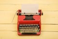 Writer or journalist workplace - vintage red typewriter on the yellow wooden desk Royalty Free Stock Photo
