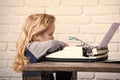 Writer kid sitting at table and typing typewriter with paper Royalty Free Stock Photo