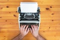 Writer`s hands. Old retro typewriter on wooden desk. Royalty Free Stock Photo