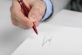 Writer signing autograph in book at table