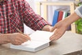 Writer signing autograph in book at table,