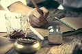 Writer at work. The hands of young writer sitting at the table and writing something in his sketchpad Royalty Free Stock Photo