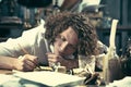 Writer at work. Handsome young writer sitting at the table and writing something in his sketchpad Royalty Free Stock Photo