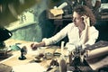 Writer at work. Handsome young writer sitting at the table and writing something in his sketchpad Royalty Free Stock Photo