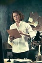 Writer at work. Handsome young writer standing near the table and making up something in his mind Royalty Free Stock Photo