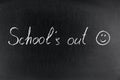 Writes the words `School`s out` and a smiling face on a chalkboard Royalty Free Stock Photo