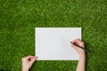 Writing on blank sheet of paper over green grass Royalty Free Stock Photo