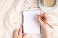 Writing check list concept. Pov top above overhead close up view photo of female hand making notes in empty notepad near white Royalty Free Stock Photo