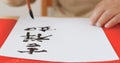 Writing Chinese calligraphy with phrase meaning wish you good fortune and may all your wishes come true Royalty Free Stock Photo