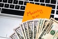 Writing on colorful sticky note Marketing plan. Dollars money on keyboard